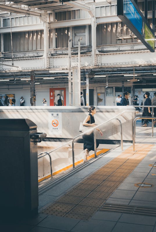 Busy Tokyo Station platform with passengers moving between JR ticket gates during rush hour