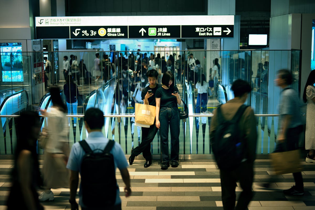 Japanese train station ticket gates with commuters, signage and IC card readers — easy to confuse JR and Metro gates