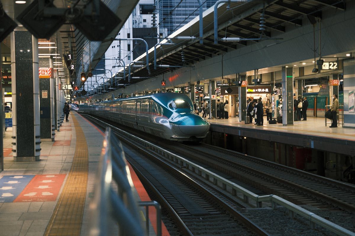 Modern Shinkansen at Tokyo Station bustling platform with passengers boarding — oversized luggage requires advance reservation